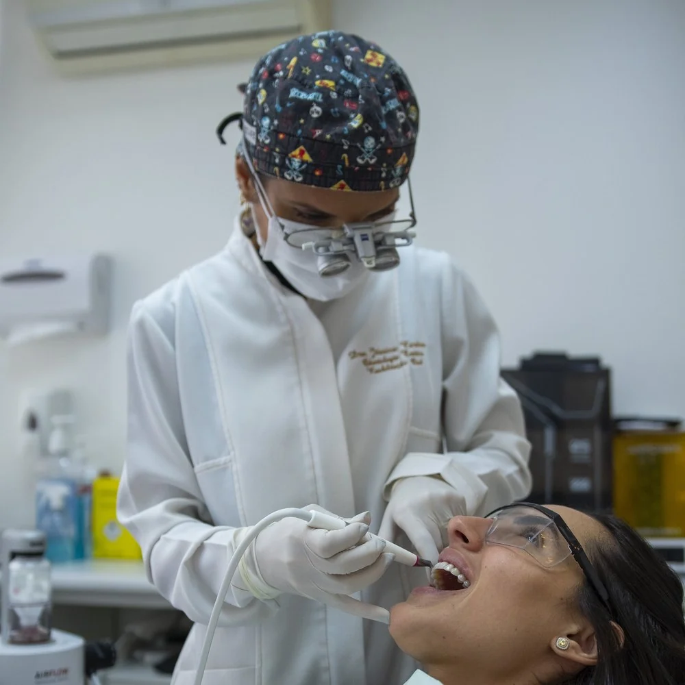 Atendimento de dentística com lupa cirúrgica